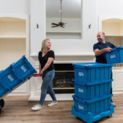 Couple smiling at each other while packing and moving items using EZPak's eco-friendly plastic bins