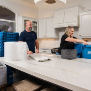 A couple packing kitchen items using EZPak's cleaner and more hygienic plastic bins