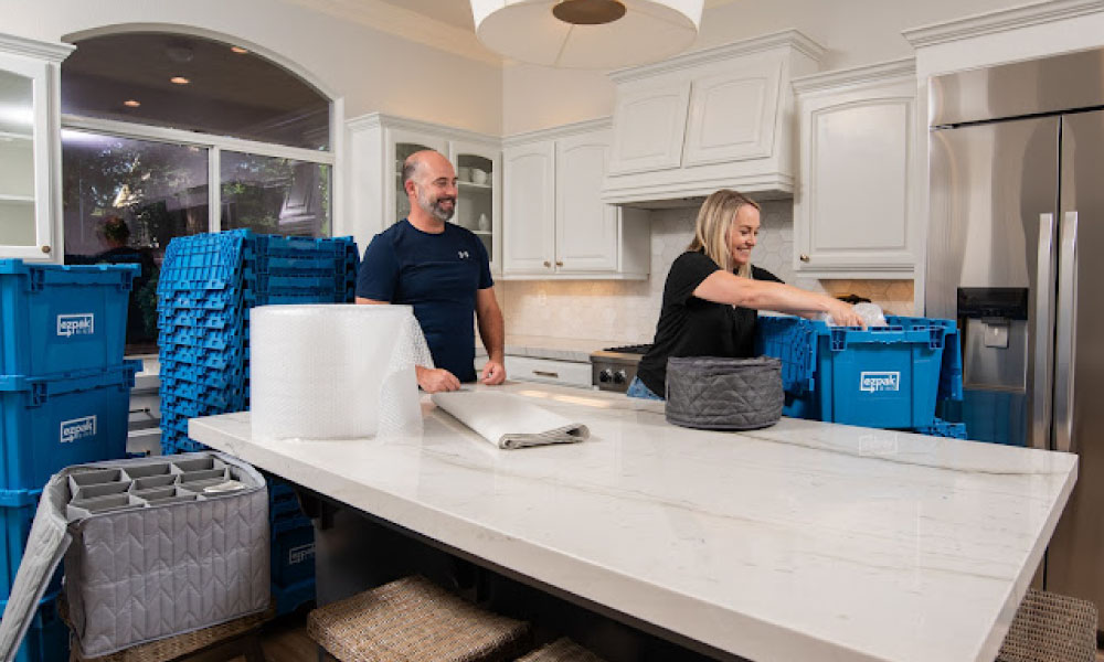 A couple packing kitchen items using EZPak's cleaner and more hygienic plastic bins