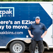 EZPak movers standing next to dolly carts and plastic bins ready to make your next Moving Services more convenient