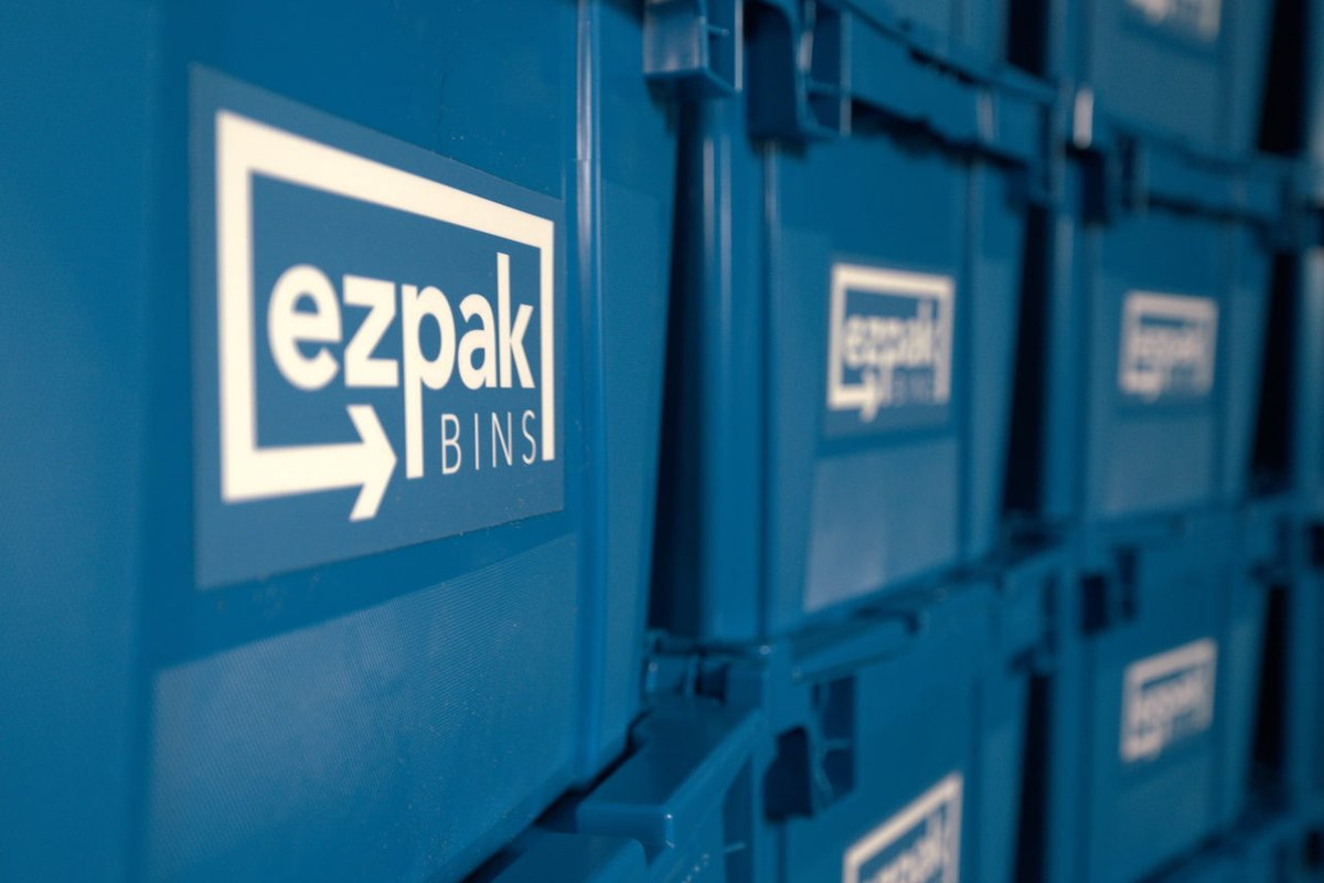 An extreme close-up of the EZPak Bins logo printed on the side of a stacked blue moving bin