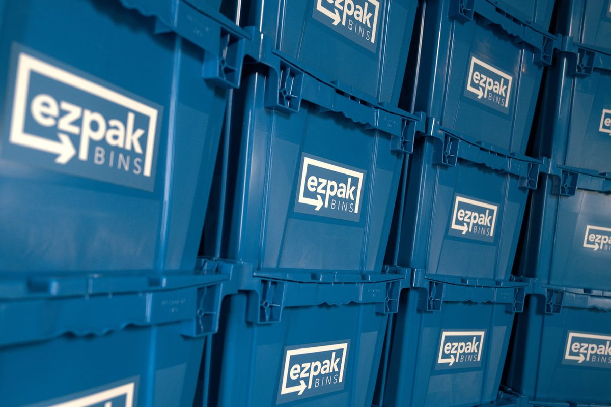 A close-up detail of blue EZPak Bins moving crates stacked closely together, showing the branded logo repeated across each bin
